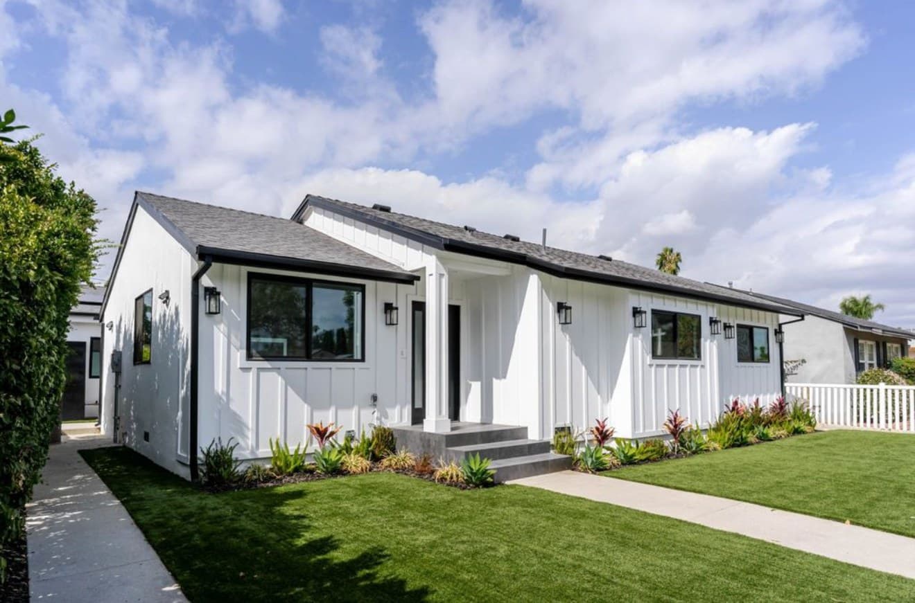 The Noir Haven residence — a white board-and-batten home with landscaped front garden